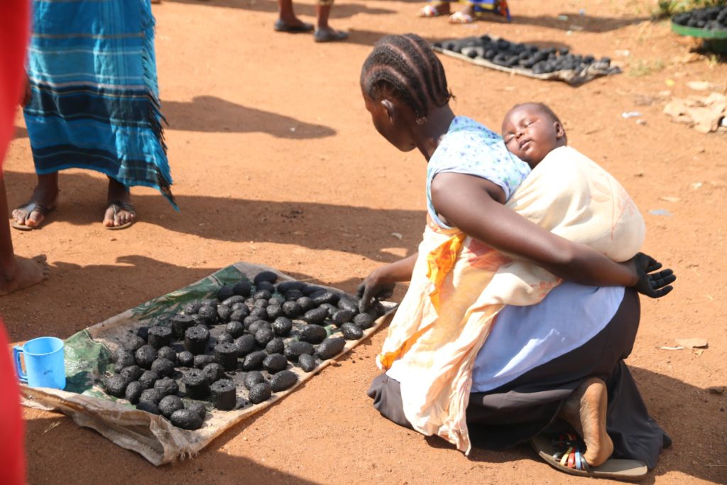 Trainee making hand molded briquettes